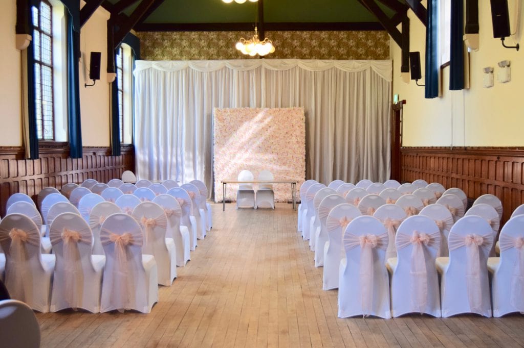 White Pleated Drape with Flower Wall, Spandex Chair Covers and Blush Pink Organza Sashes