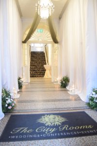 White Pleated Drape Hallway Decoration with Cylinder Vase Decoration and Fresh Floral Arrangements