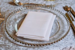 Silver Beaded Charger Plate with White Napkin on top of Crushed Velvet Table Cloth